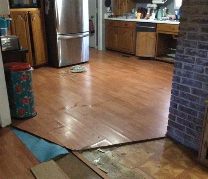 A wood laminate kitchen floor that has a water damage